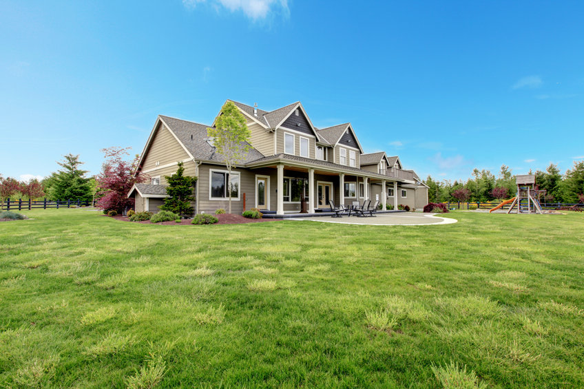 Large farm country house with spring green landscape, kids play ground.